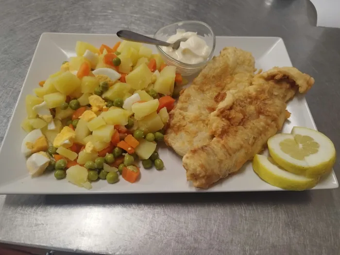 Filetes de peixe frito com batata, cenoura, ervilhas, ovo cozido, maionese e limão