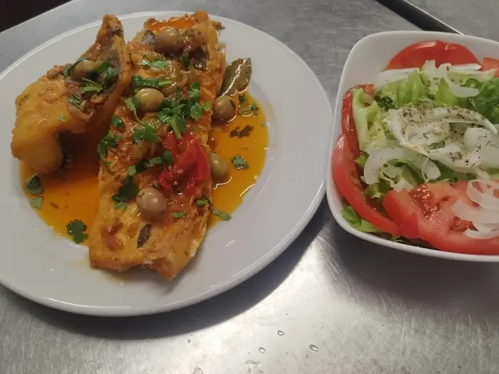 Peixe em molho servido com salada de tomate